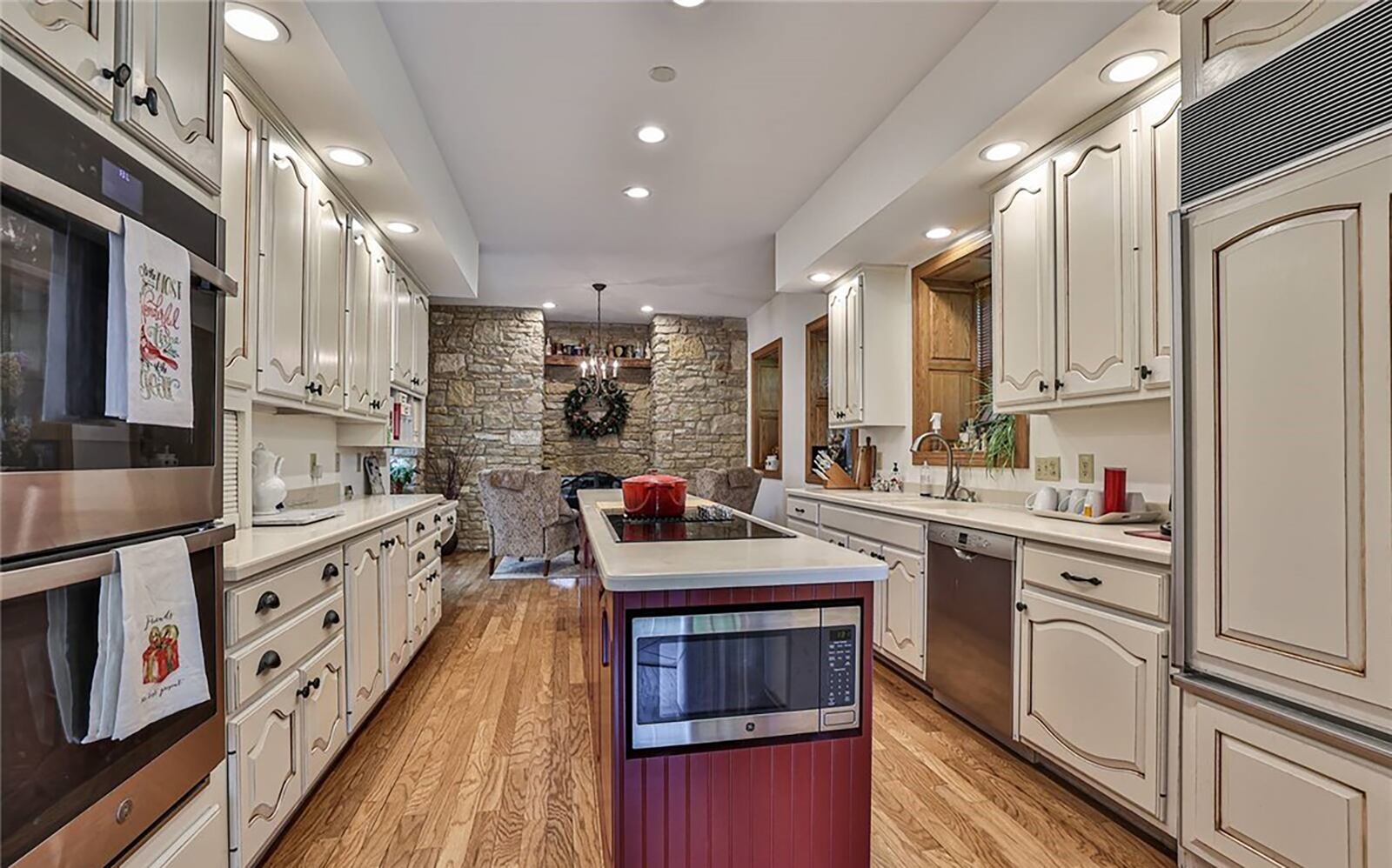 The galley style kitchen has a breakfast nook at one end with a stone fireplace and a living room at the other. It has been completely updated with all modern appliances including a subzero refrigerator.