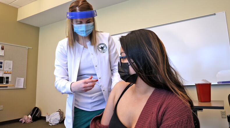 Sophie Gustafson, a nursing student at Clark State College, gives Mikhaela Cando a COVID vaccine injection on April 16 at a clinic on the Leffel Lane campus. In an attempt to get more people vaccinated, the Clark County Combined Health District has been holding 'pop-up' style clinics across the county. BILL LACKEY/STAFF