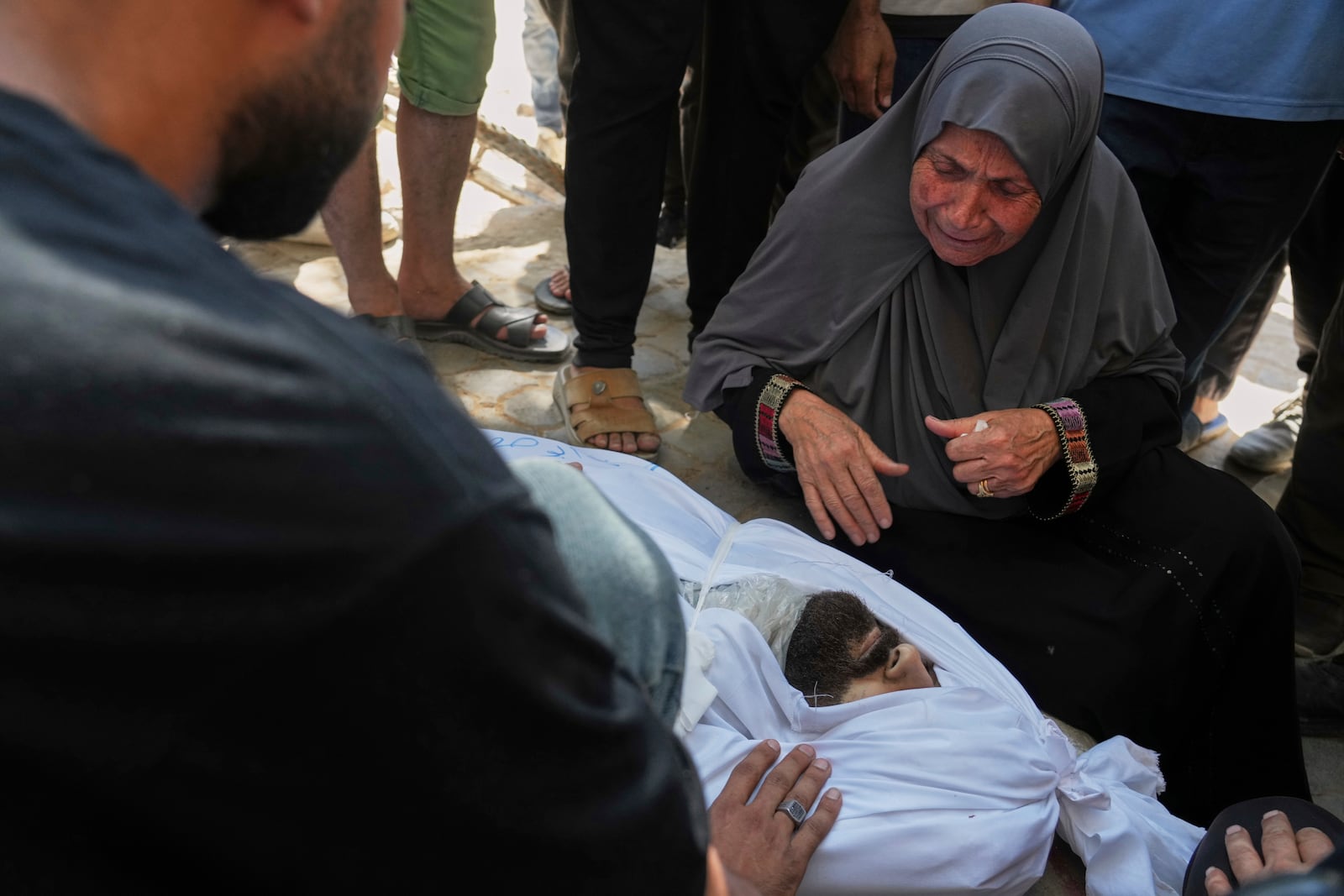 The mother of the Palestinian journalist Ismail Abu Hatab, who was killed in an Israeli strike on a cafe, mourns over the body of her son as she stands outside the Shifa Hospital, Gaza City, Monday, June 30, 2025.(AP Photo/Jehad Alshrafi)
