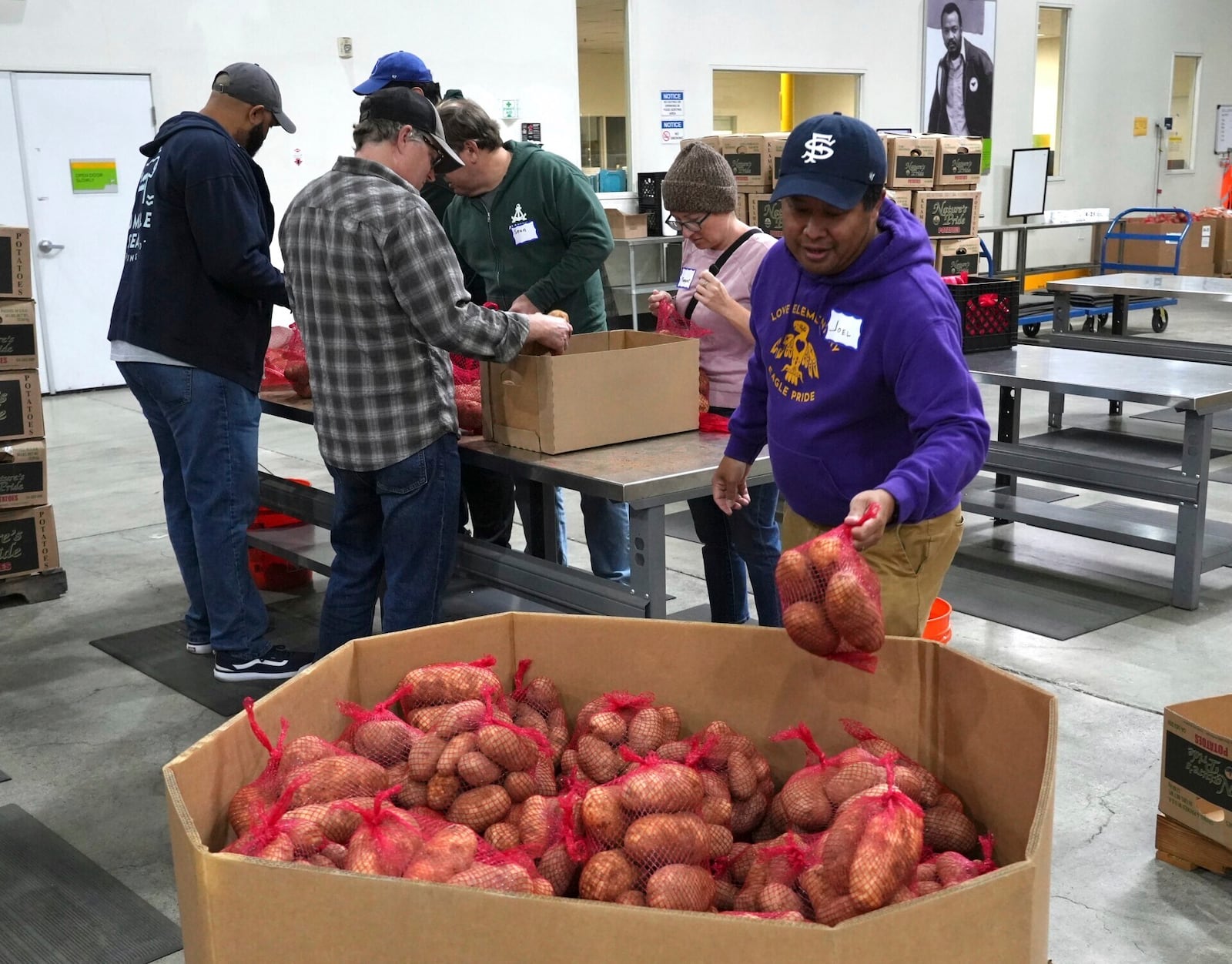 Volunteers pack produce at the Alameda County Community Food Bank in Alameda, Calif., on Friday, April 25, 2025. (AP Photo/Terry Chea)
