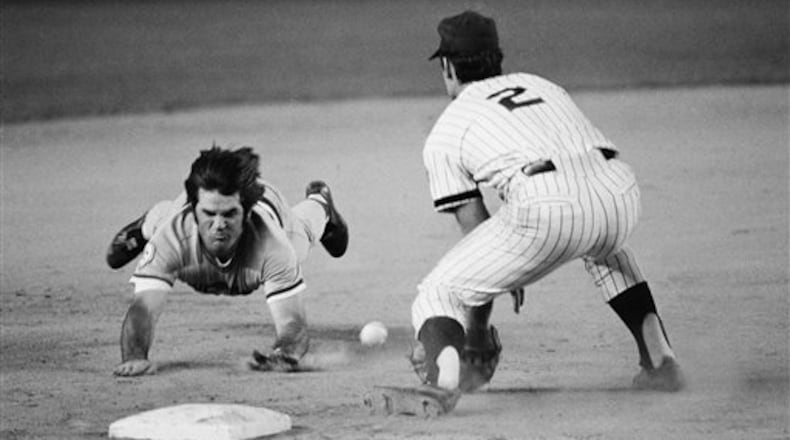 Pete Rose of the Cincinnati Reds slides head first, feet in the air, as he races the ball for third base with a seventh inning triple at Shea Stadium in New York, Friday, August 13, 1976. New York Mets third baseman Roy Staiger, (right) awaits the late throw from rightfielder Mike Vail. (AP Photo/Ray Stubblebine)
