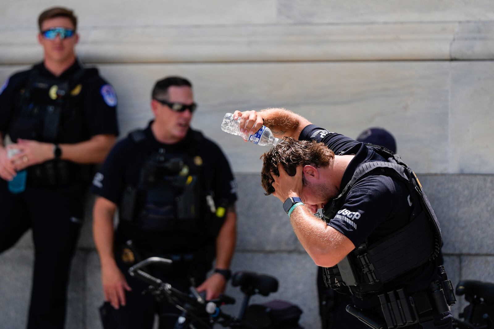 A U.S. Capitol Police officer pours water on his head, Wednesday, June 25, 2025, outside the Capitol in Washington. (AP Photo/Julia Demaree Nikhinson)