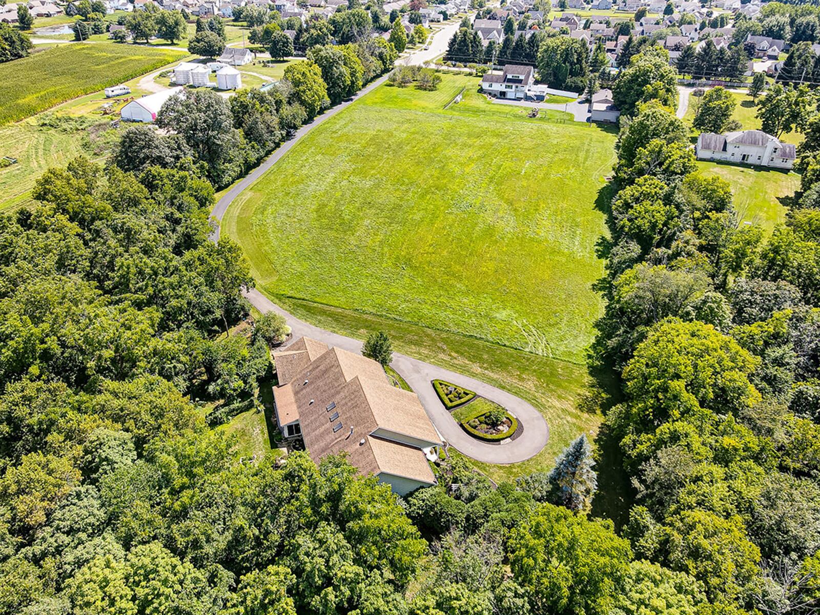The rear is set back among the trees and has walking trails throughout the more than 9-acre property. There is a yard shed, freestanding deck and stone steps leading to the woods. CONTRIBUTED PHOTO
