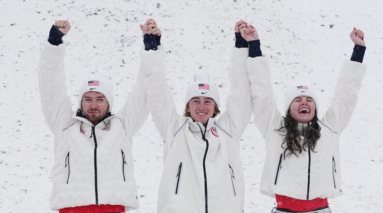 From left, gold medalists United States' Christopher Lillis, Connor Curran and Kaila Kuhn celebrates after the freestyle skiing mixed team aerials final at the 2026 Winter Olympics, in Livigno, Italy, Saturday, Feb. 21, 2026. (AP Photo/Gregory Bull)