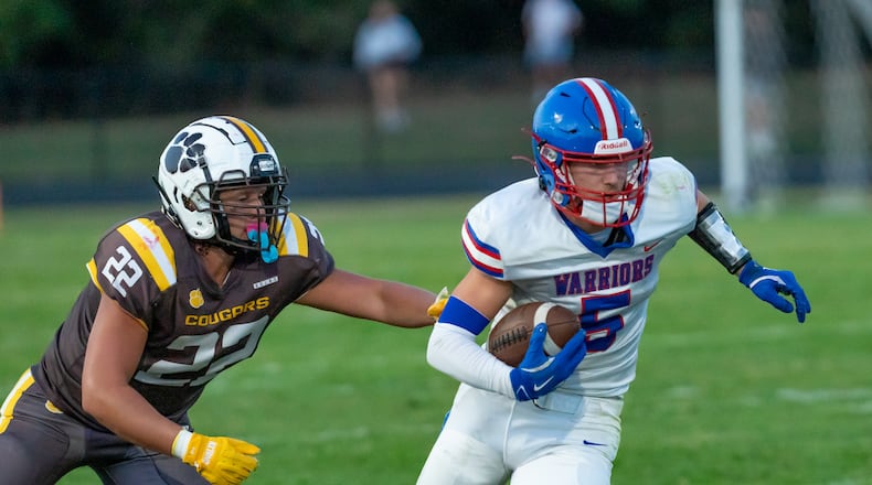 Northwestern High School junior Rennen Smith runs past Kenton Ridge senior Aidan Pennington during their game on Friday, Sept. 19 at Richard L. Phillips Field in Springfield. The Cougars won 21-17. RODNEY GETZ/CONTRIBUTED PHOTO