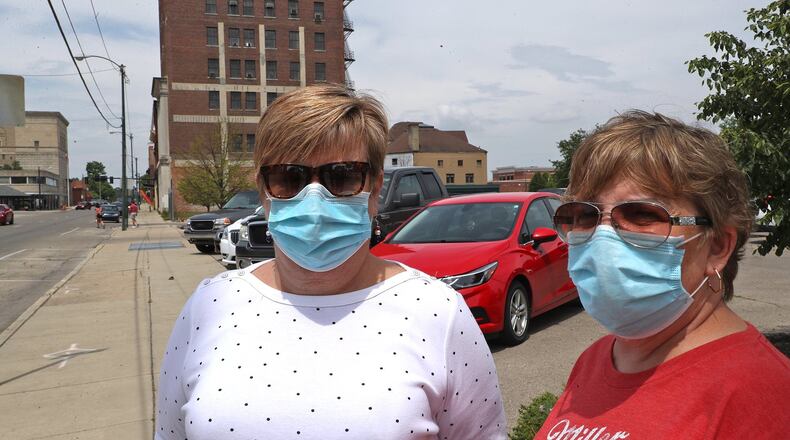 Tracy Wickham, left, and Denise See, who both work at United Senior Services, were wearing their masks as they took a walk around downtown Springfield Friday. BILL LACKEY/STAFF