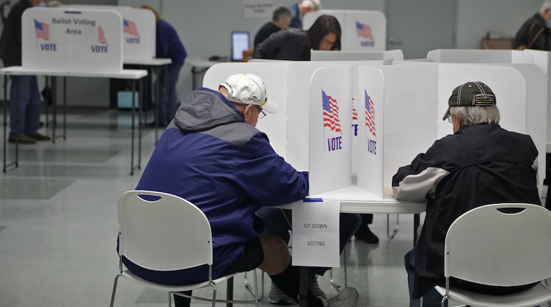 Voters fill out their ballots Tuesday at Enon Knob Prairie United Church in Mad River Township. BILL LACKEY/STAFF