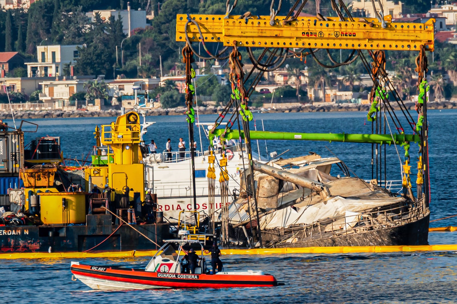 The hull of the superyacht Bayesian, which sank near Palermo, Sicily, on August 19, 2024, is lifted by cranes during salvage operations off the village of Porticello Saturday, June 21, 2025. (AP Photo/Salvatore Cavalli)