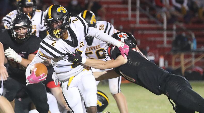 Shawnee's Jamon Miller tries to avoid a tackle by Tecumseh's Braden Berner earlier this season. BILL LACKEY/STAFF