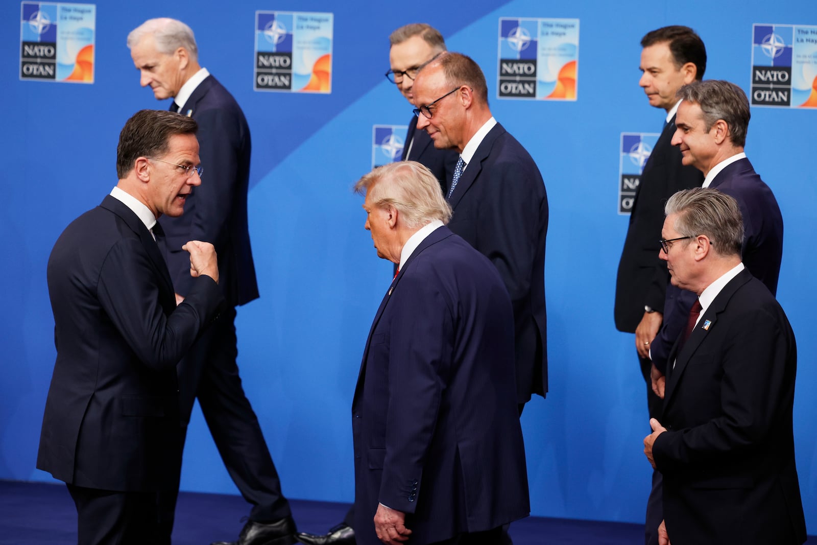 NATO Secretary General Mark Rutte, left, speaks with President Donald Trump, center, and Britain's Prime Minister Keir Starmer, right, after a group photo of NATO heads of state and government at the NATO summit in The Hague, Netherlands, Wednesday, June 25, 2025. (AP Photo/Geert Vanden Wijngaert)