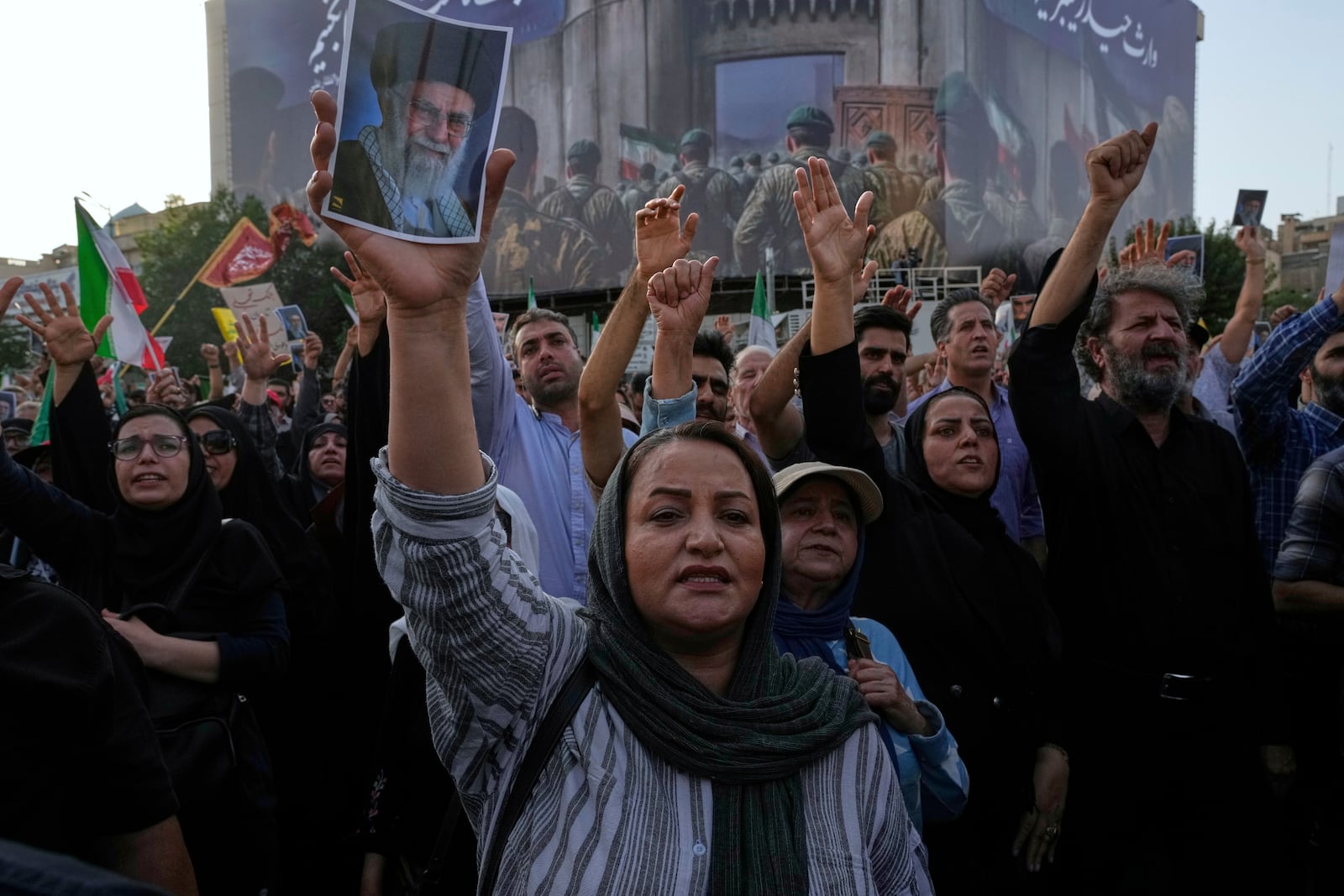 Protesters chant slogans as one of them holds up a poster of the Iranian Supreme Leader Ayatollah Ali Khamenei in a protest following the U.S. attacks on nuclear sites in Iran, in Tehran, Iran, Sunday, June 22, 2025. (AP Photo/Vahid Salemi)