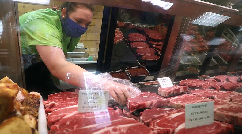 ORIGINAL CUTLINE: Sidney Ballweg, an employee at Copey’s Butcher Shop, picks out some steaks for a customer Friday. BILL LACKEY/STAFF