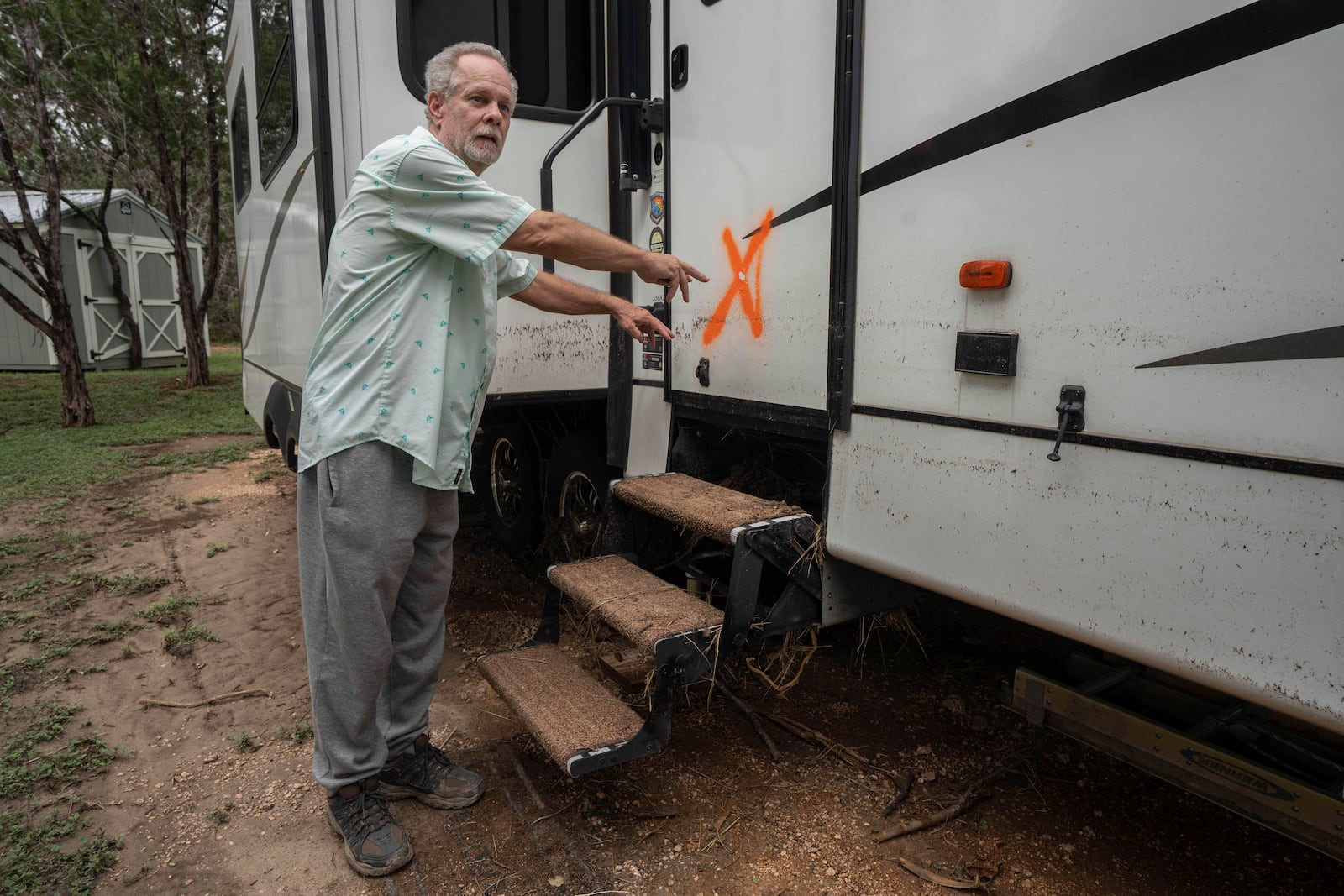 Curtis Beal motions to how high waters rose while describing the flash flood he experienced at Cedar Stays RV Park in Marble Falls, Texas, Monday, July 7, 2025. (Mikala Compton /Austin American-Statesman via AP)