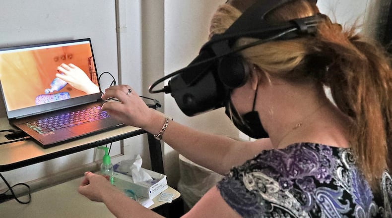 A subject wears wears a virtual reality headset as she participates in the Embodied Labs program at the Springfield Masonic Community Friday, July 1, 2022. The device puts nurses and other caregivers in the position of someone with cognitive or physical problems. BILL LACKEY/STAFF