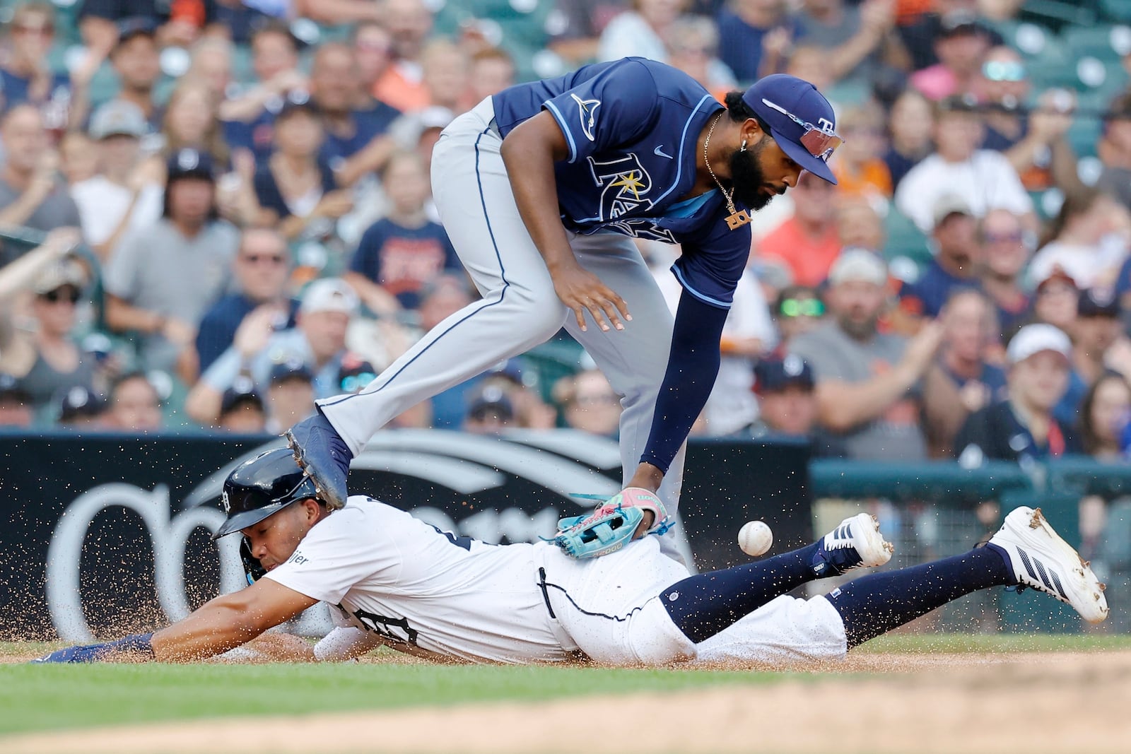 Tampa Bay Rays third baseman Junior Caminero loses the ball while tagging Detroit Tigers' Zach McKinstry sliding into third base during the fourth inning of a baseball game Wednesday, July 9, 2025, in Detroit. (AP Photo/Duane Burleson)