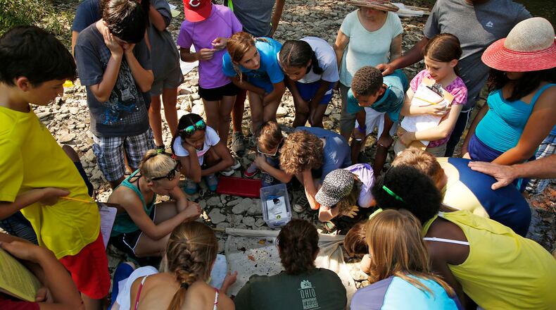 Students from McKinney Middle School in Yellow Springs work on science activities in a creek bed as part of a three-day bike trip along the Little Miami River in 2016. Yellow Springs schools have emphasized project-based learning. TY GREENLEES / STAFF