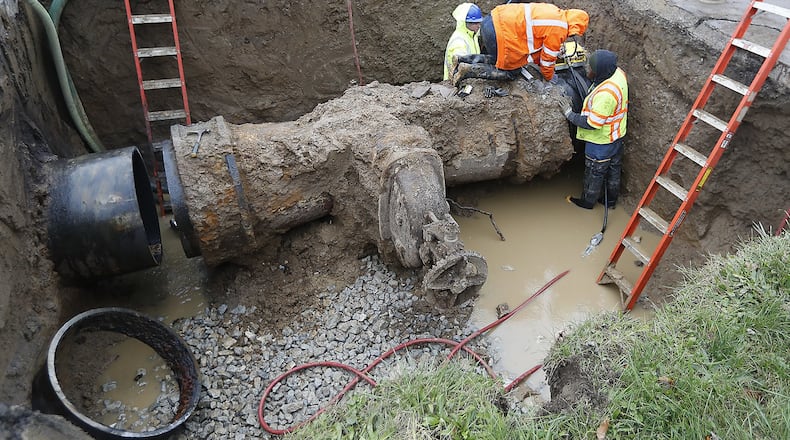 Workers from the City of Springfield Water and Sewer Department replace a valve on a 36 inch water line Wednesday under Lexington Avenue. The valve, installed in the 1920’s, weighed 14,000 pounds and is being replaced with a valve that only weighs 8,000 pounds. Bill Lackey/Staff
