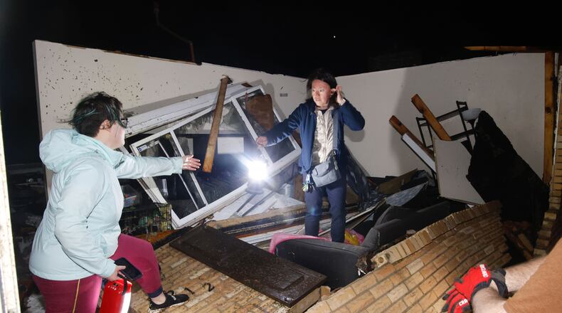 Emi Campbell and her daughter Emma search their Ridge Road house early Wednesday morning, Feb. 28, 2024, after it sustained extensive damage from a possible tornado. BILL LACKEY/STAFF