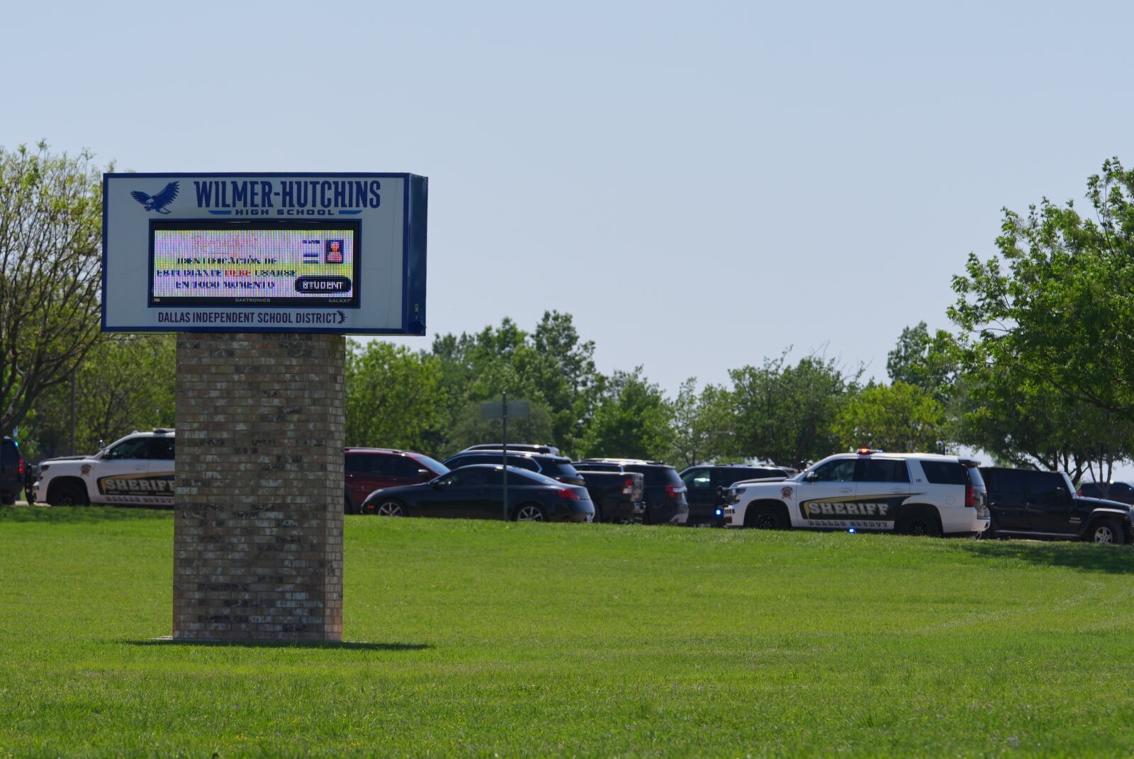 Sheriff vehicles sit parked in a lot at Wilmer-Hutchins High School, where police are responding to reports of a shooting at in Dallas, Tx., Tuesday, April 15, 2025. (AP Photo/Julio Cortez)