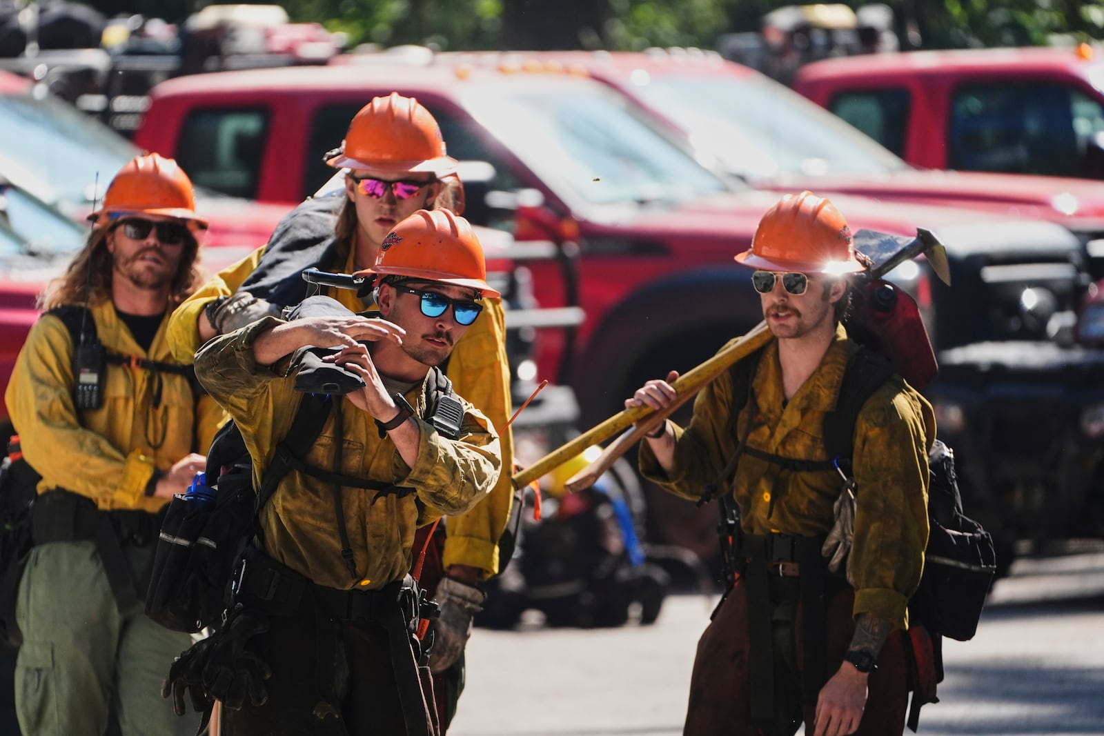 Wildland firefighters with the United States Forest Service prepare at a staging area near the scene the day after a shooter ambushed and killed multiple firefighters responding to a wildfire at Canfield Mountain Monday, June 30, 2025, in Coeur D'Alene, Idaho. (AP Photo/Lindsey Wasson)