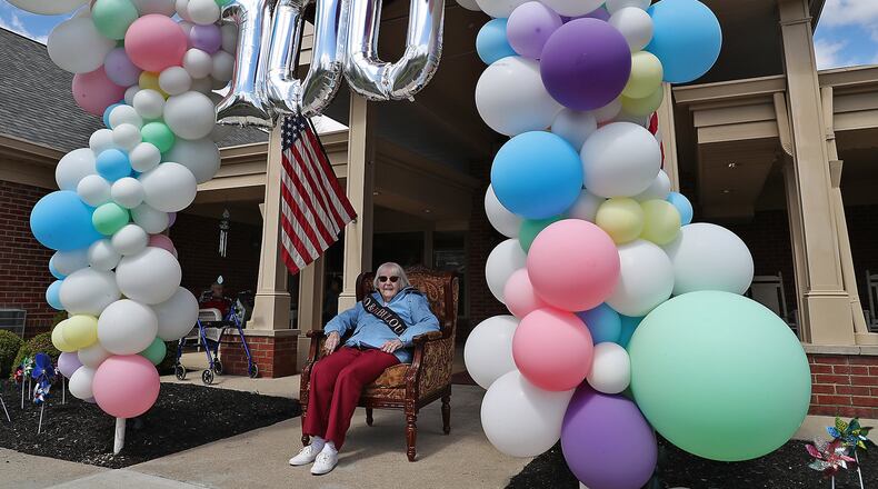 Ruth Bayley, a lifelong Springfield resident and Wittenberg alumni, sits in her seat of honor in front of Hearth and Home care center as she waits for the birthday parade to drive past to celebrate her 100th birthday. BILL LACKEY/STAFF