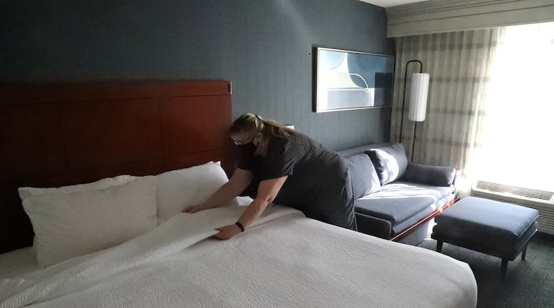 Kelli Benjamin, an employee at the Courtyard by Marriott hotel, cleans one of the guest rooms Friday. BILL LACKEY/STAFF