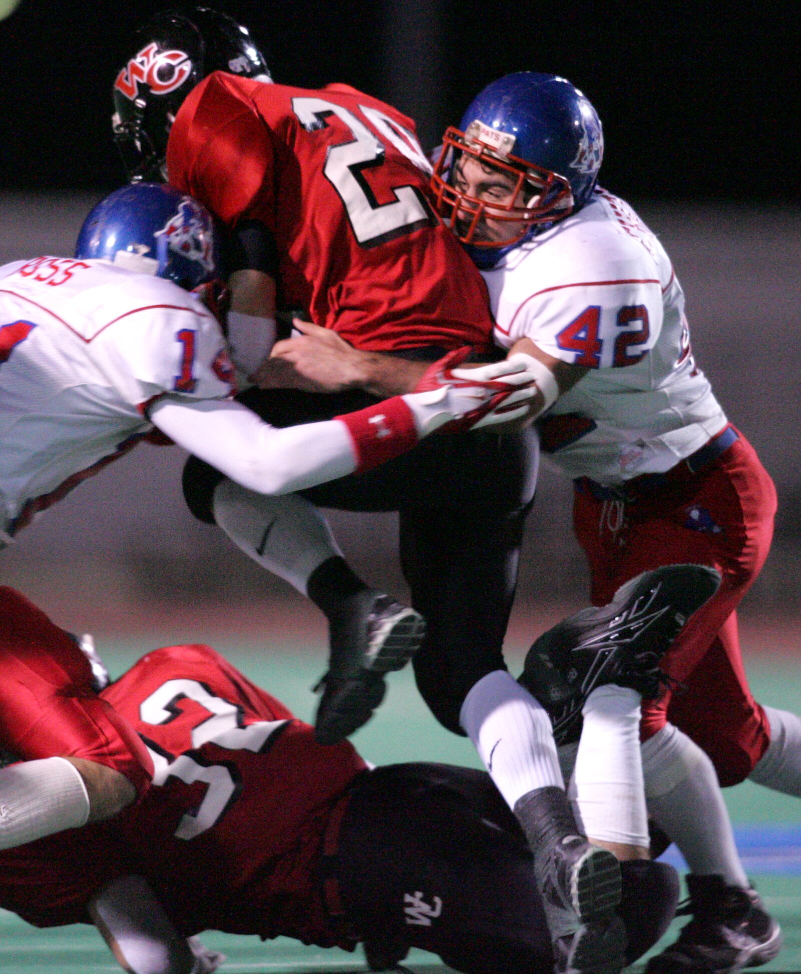 James Ross (left) and Tony Chitwood Jr (right), of the Carroll High School defense, tackle Matt Evans, a West Carrollton running back. The two teams played in a Division II Region 8 semifinal game. The game was played at Welcome Stadium. RON ALVEY / STAFF PHOTO