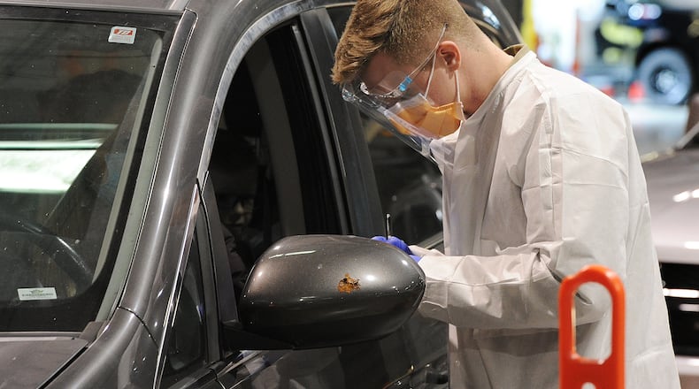 Members of the Ohio National Guard work with Dayton Children's staff at the Dayton Children's Springboro COVID-19 testing site Thursday Jan. 13, 2022. MARSHALL GORBY\STAFF