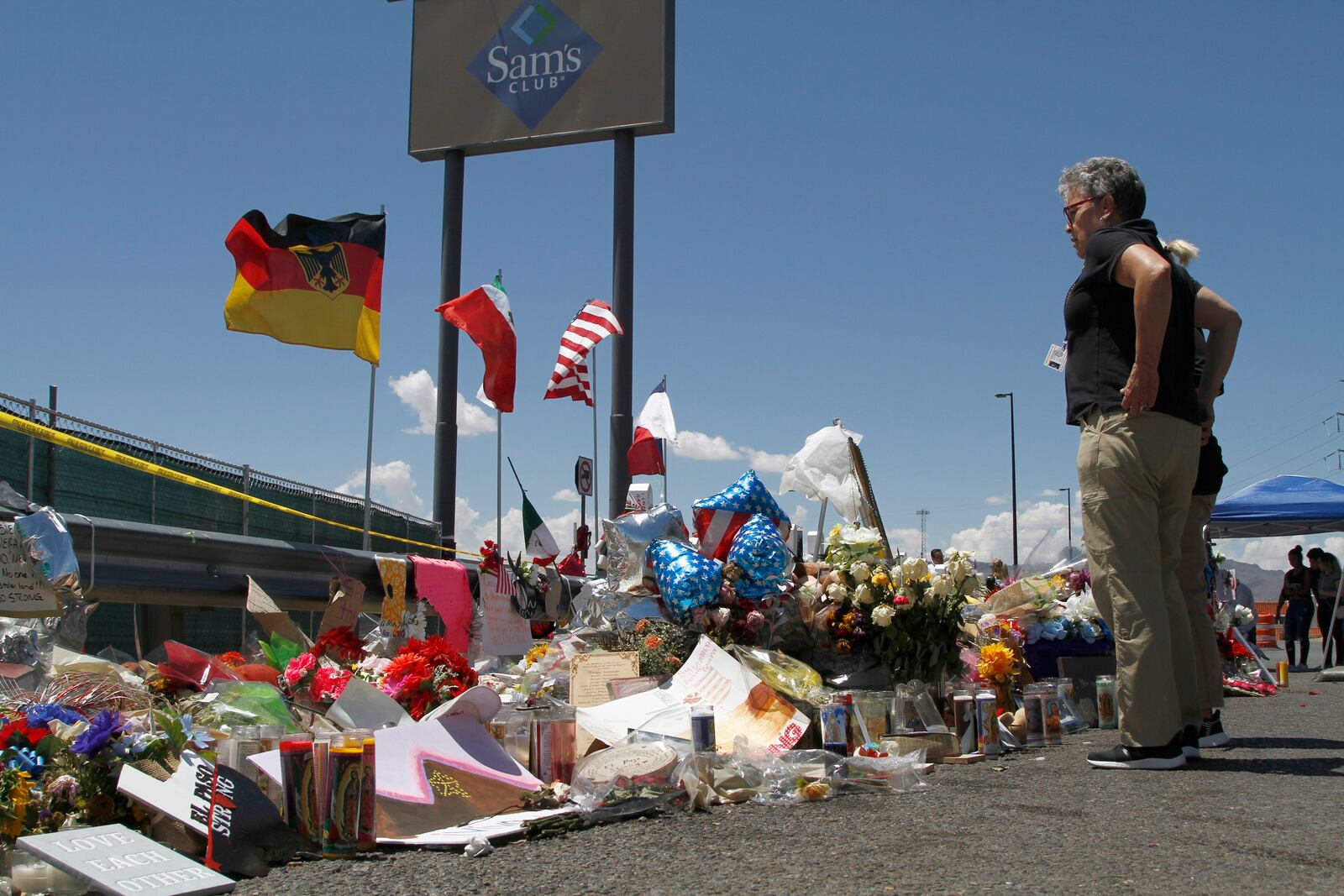 FILE - Mourners visit a makeshift memorial on Aug. 12, 2019, near the Walmart in El Paso, Texas, where people were killed in a mass shooting. (AP Photo/Cedar Attanasio, File)