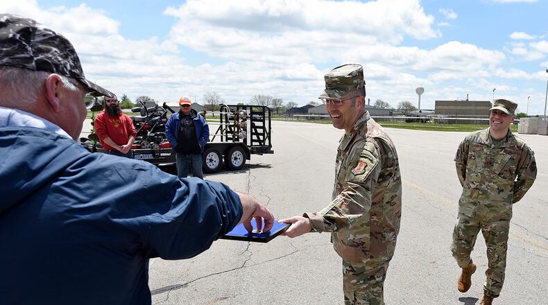 Air Force Col. Thomas P. Sherman, 88th Air Base Wing commander, awards 88th Civil Engineer Squadron Area B ground maintenance supervisor Bryan Spiller with an 88th ABW challenge coin at Wright-Patterson Air Force Base, May 1. U.S. Air Force photo by Ty Greenlees