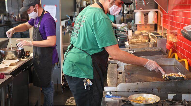 Louie Ortega and his staff at the Painted Pepper restaurant in COhatch still wear their masks on Tuesday but he said since his staff is all vaccinated, he will not require it when the mask mandate is lifted. BILL LACKEY/STAFF