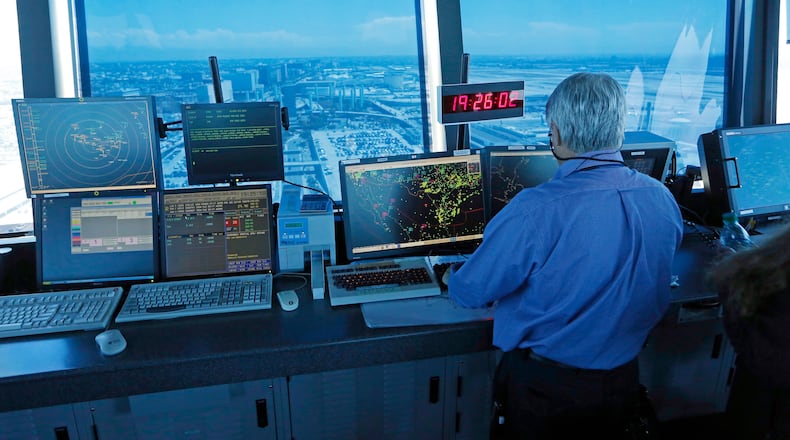 FILE - In this Sept. 4, 2013 photo, an air traffic controller works at computer screens and a digital clock showing Coordinated Universal Time (UTC), or Zulu time, is seen in this view looking eastward from the control tower at Los Angeles International Airport (LAX). (AP Photo/Reed Saxon, File)