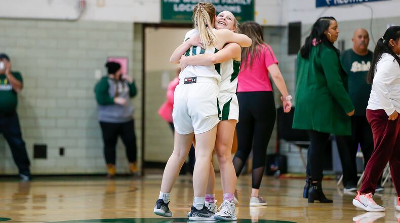 Cutline: Catholic Central High School senior Meghan Foster hugs fellow senior Serenity Castle after the Irish beat Greenon 43-38 on Saturday afternoon at Jason Collier Gymnasium to clinch at least a share of the Ohio Heritage Conference South Division championship for the second straight season. CONTRIBUTED PHOTO BY MICHAEL COOPER