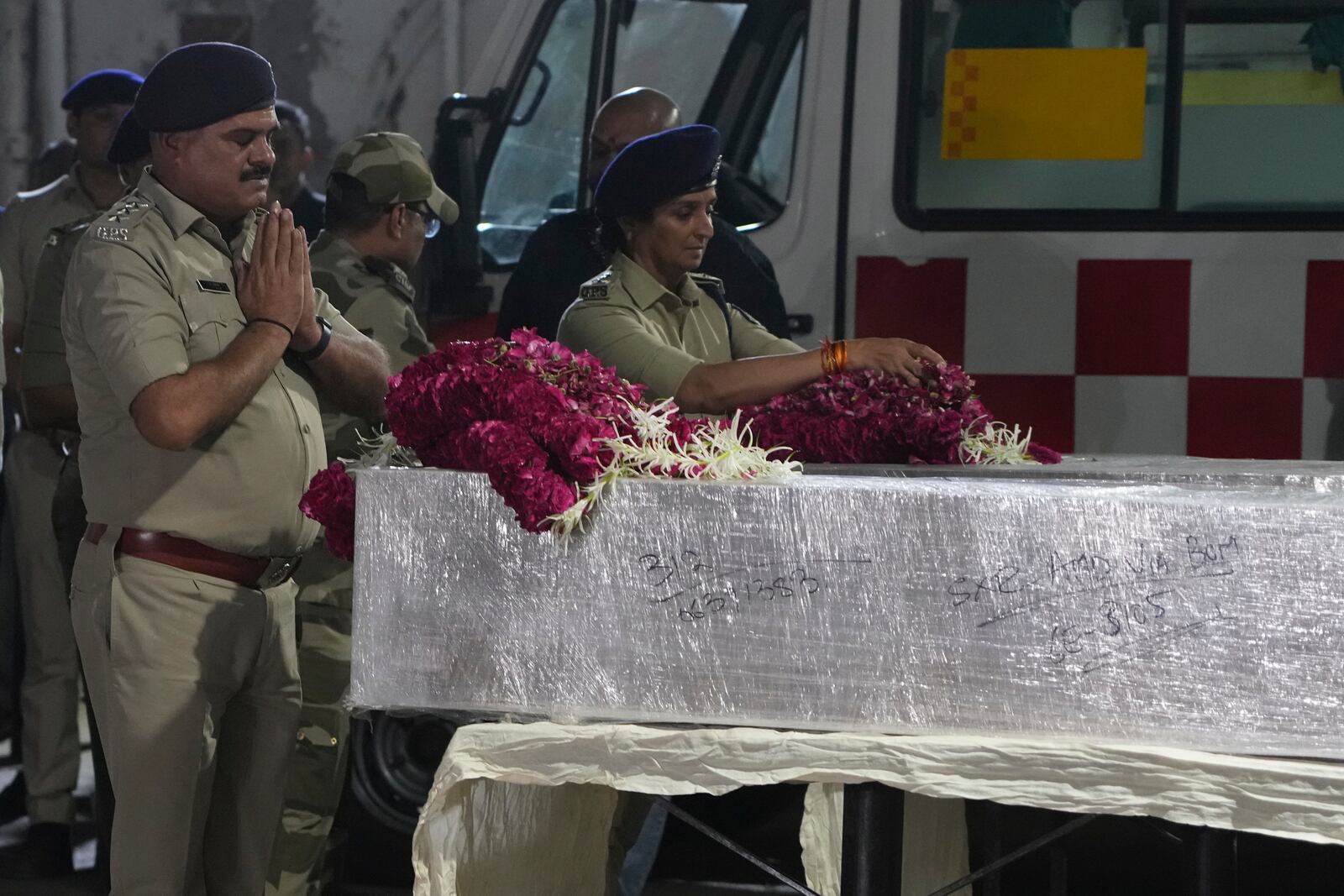 Police officers pay tribute to the victims who were killed by militants near Pahalgam in Indian-controlled Kashmir, after the bodies arrived at an airport in Ahmedabad, India, Wednesday, April 23, 2025. (AP Photo)