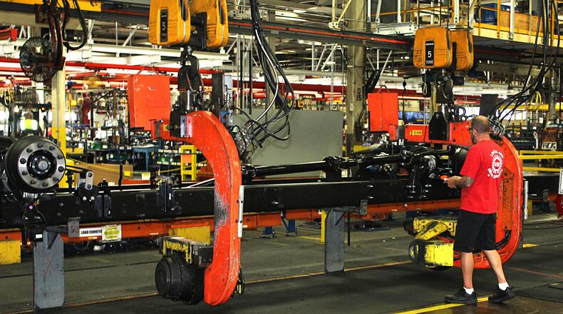 A Navistar International employee gets ready to flip a truck chassie on the assembly line. JEFF GUERINI/STAFF September 21 2018