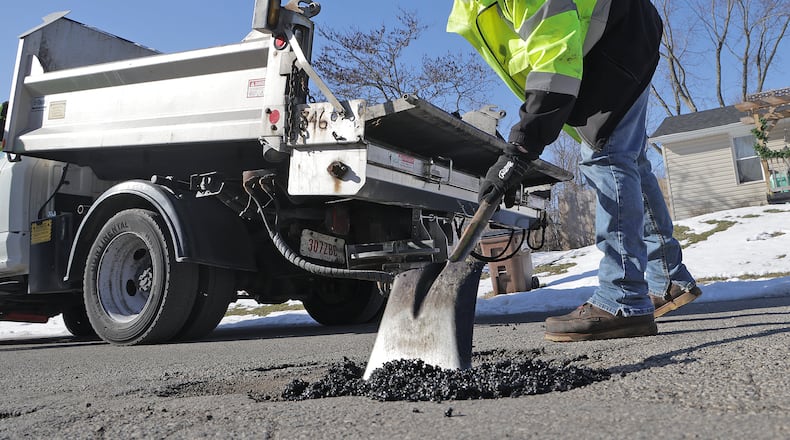 Tait Schnitzler, an employee of the City of Springfield, patches a pot hole along Superior Avenue Tuesday, Jan. 28, 2025. BILL LACKEY/STAFF