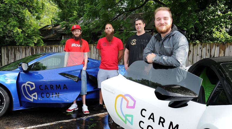 The creators of Carma Coin, in Yellow Springs, from left, Brad Butcher, Cecil Mark, Scott Morin and David Butcher. MARSHALL GORBY\STAFF