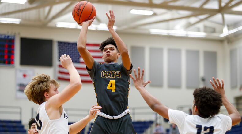 Springfield High School sophomore Shawn Thigpen shoots over Fairmont's Caleb Fortener (left) and Anthony Johnson (right) during their game on Tuesday night at Trent Arena. The Wildcats on 46-44. Michael Cooper/CONTRIBUTED