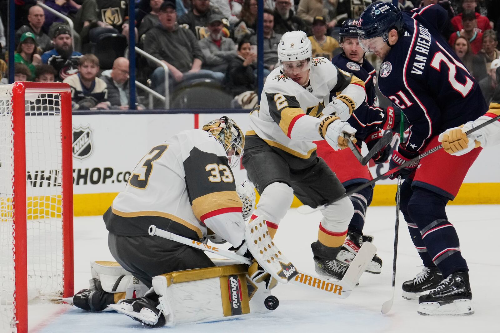 Vegas Golden Knights goaltender Adin Hill (33) blocks a shot by Columbus Blue Jackets left wing James van Riemsdyk (21) as defenseman Zach Whitecloud (2) defends in the second period of an NHL hockey game Thursday, March 13, 2025, in Columbus, Ohio. (AP Photo/Sue Ogrocki)