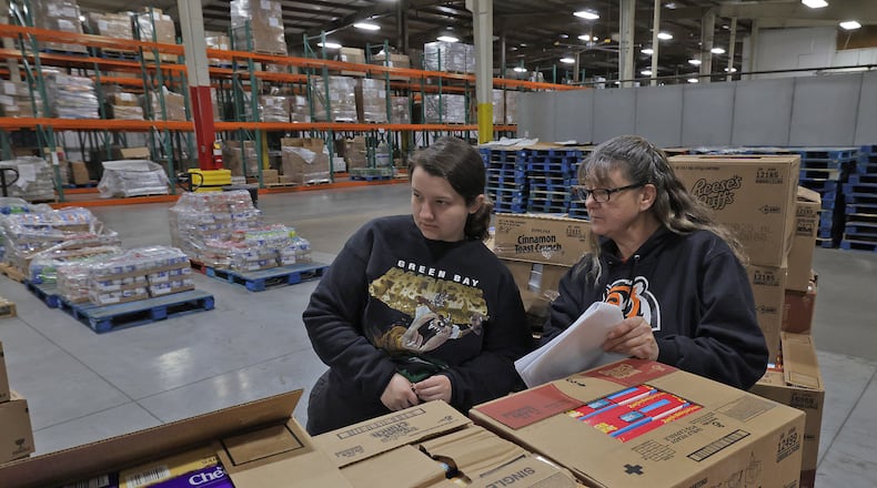 Keara Phillips and Dixie Gochenouer sort through a shipment of food at the Second Harvest Food Bank on Friday, March 28, 2025. BILL LACKEY/STAFF