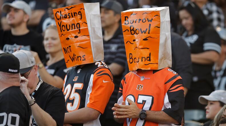 Cincinnati Bengals fans wears paper bags on their heads during the second half of an NFL football game against the Oakland Raiders in Oakland, Calif., Sunday, Nov. 17, 2019. (AP Photo/Ben Margot)