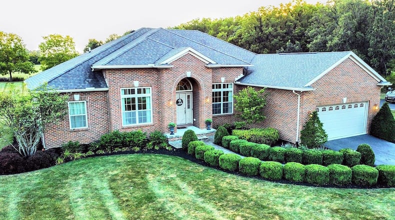 The front of the brick ranch home has a two car attached garage with openers and a covered entry. It has been recently landscaped.