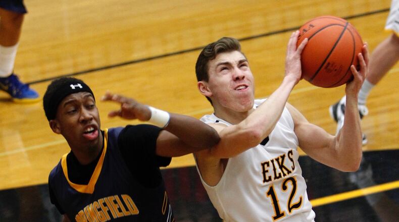 Centerville High School's Mitch Balser puts up a shot while being defended by Springfield High School's Anthony Freeman Friday night in Centerville.  LISA POWELL / STAFF PHOTO