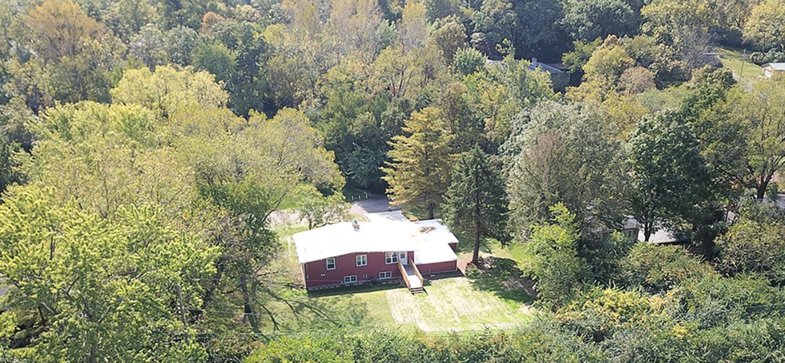 The rear of the home shows the partially wooded .44-acre lot, a new catwalk-style deck leading to the second level and many mature trees. CONTRIBUTED PHOTO