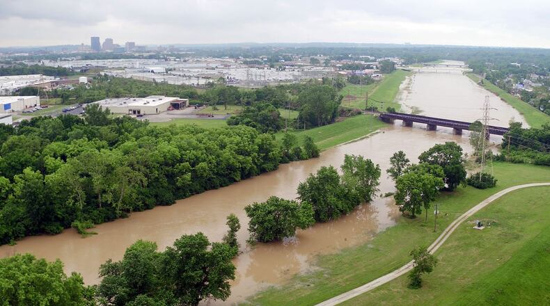 Heavy rain has the Great Miami River creeping out of its normal channel near the Kittyhawk Golf Course in Dayton. TY GREENLEES / STAFF
