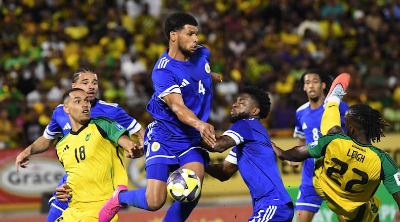 Curacao's Roshon Van Eijma, in the air, fights for the ball with Jamaica's Gregory Leigh, right, and Jonathan Russell during a World Cup 2026 qualifying soccer match in Kingston, Jamaica, Tuesday, Nov. 18, 2025. (AP Photo/Collin Reid)
