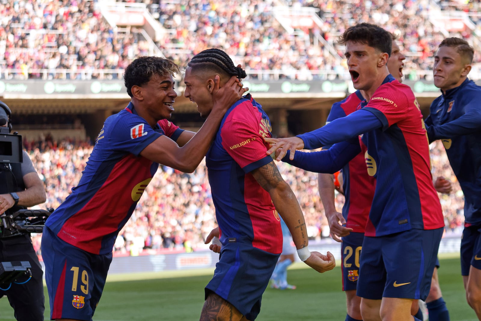 Barcelona's Raphinha, centre, celebrates with teammates after scoring his side's fourth goal during a Spanish La Liga soccer match between Barcelona and Celta de Vigo at the Lluis Companys Olympic stadium in Barcelona, Spain, Saturday, April 19, 2025. (AP Photo/Joan Monfort)