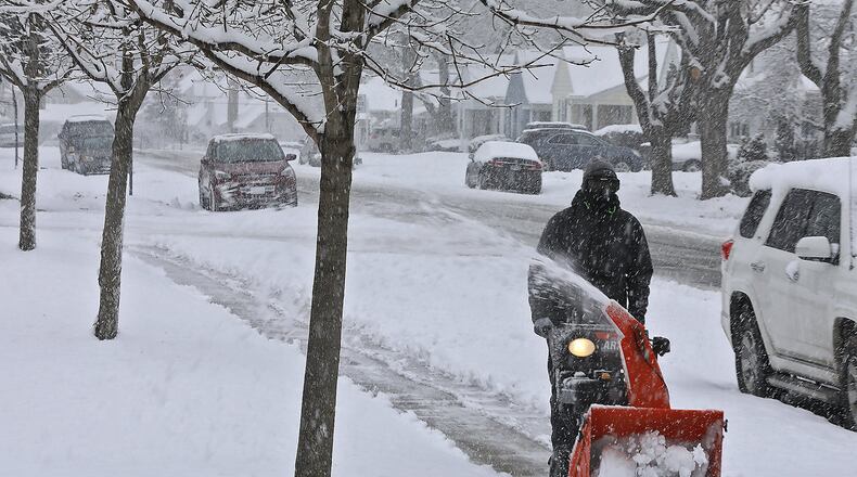 Devin Black cleans off the sidewalk behind Snyder Park Elementary on Dec. 13 in Springfield. Bill Lackey/Staff