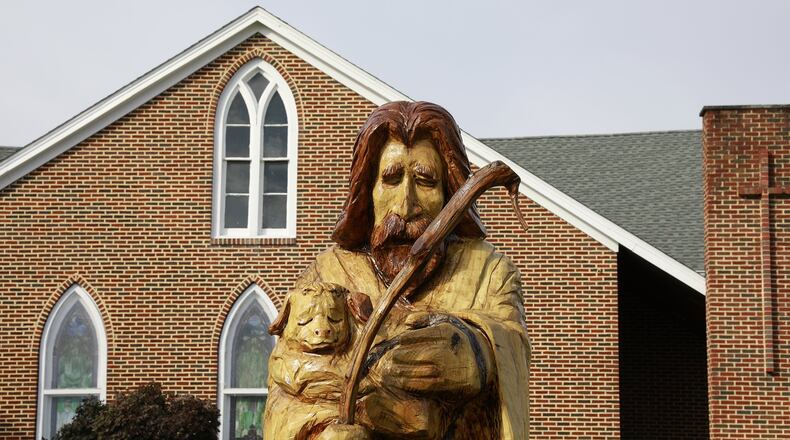 A tree, which once stood in front of the Grace United Methodist Church was carved into a shephard by a local artist. Bill Lackey/Staff