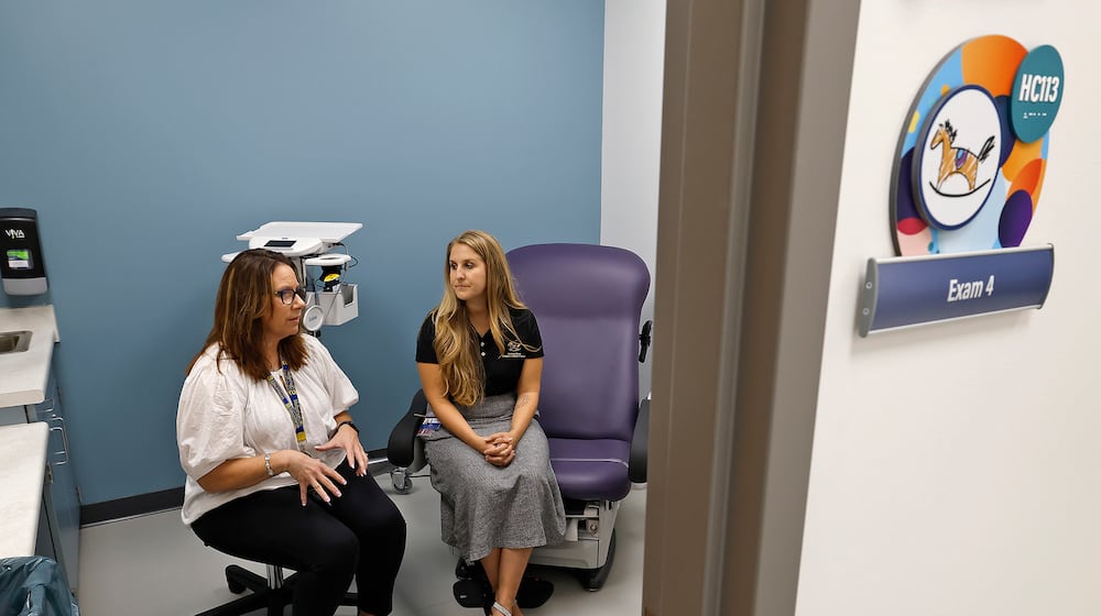 Anita Biles, from Springfield City Schools, left, and Amanda Ambrosio, from the Rocking Horse Center, discuss the success of The Health Center at Springfield High School Thursday, Sept. 26, 2024. BILL LACKEY/STAFF